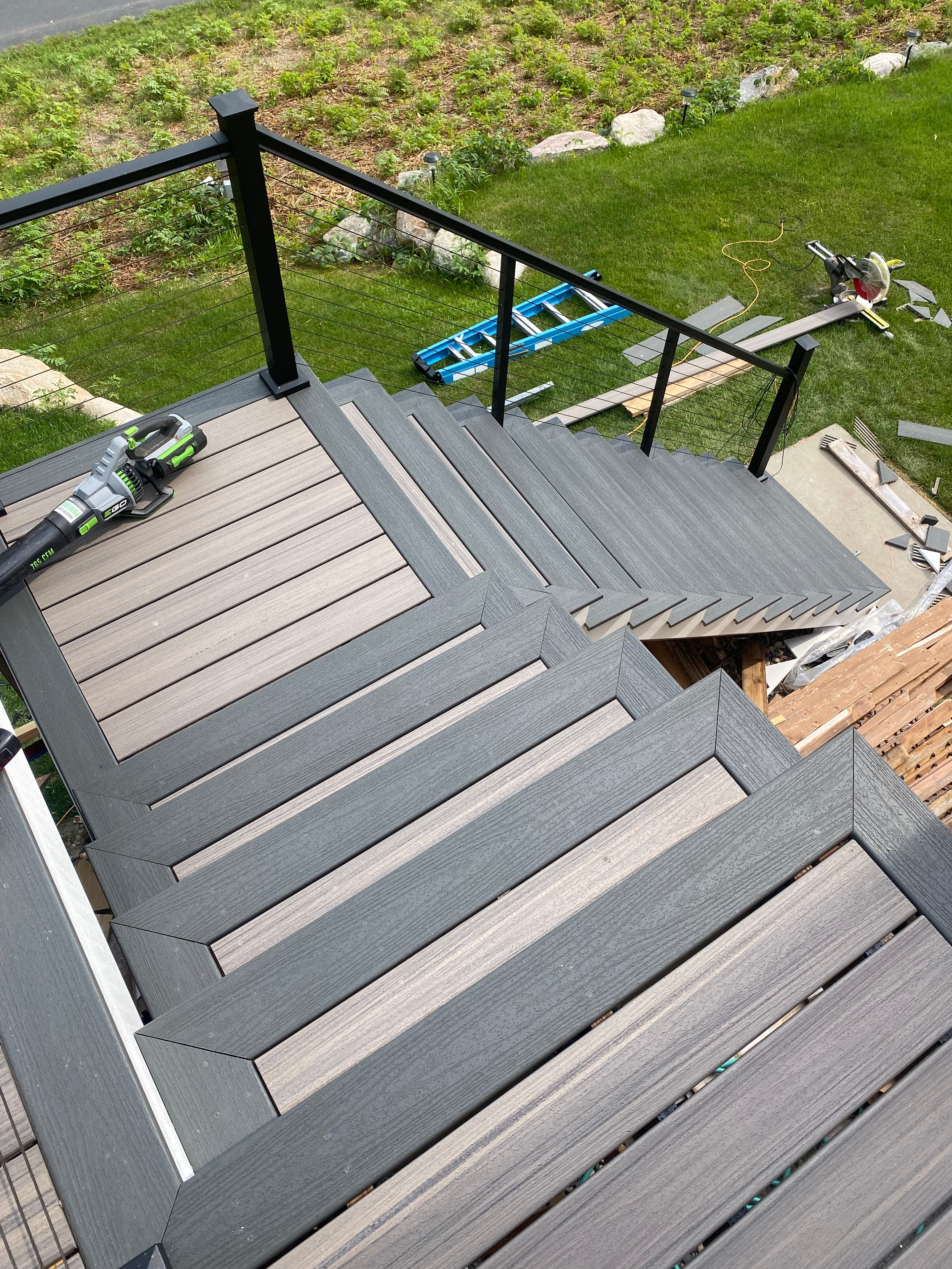 Lakeside Composite Deck — natural wood deck with black balusters and lake view